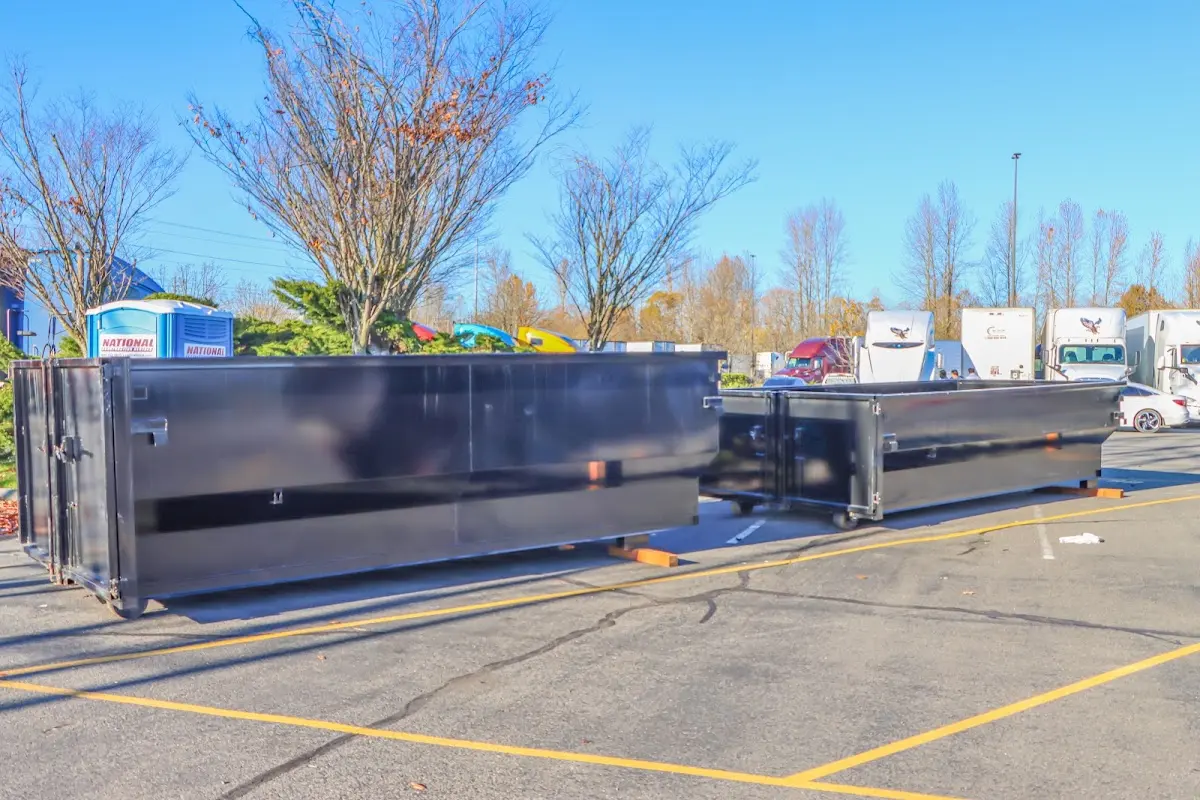 Professional dumpster rental service with roll-off container on residential driveway in Monessen